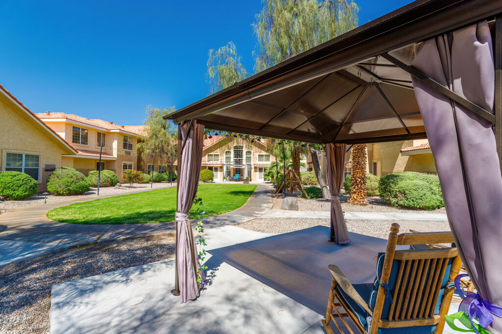 Exterior image a patio with covered seating and greenery at Vista Pointe at Lake Havasu City, a senior living community near Bullhead City.